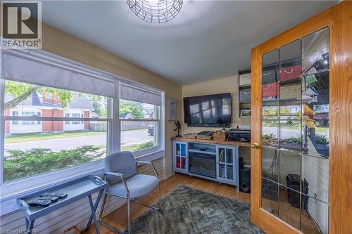 Room featuring large windows with privacy shades, wood-finish flooring, and a decorative light fixture - 5 Hawthorne Avenue, Simcoe, ON - Indoor