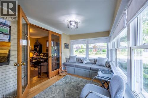 Bright sunroom with extensive windows, built-in window seating, and a modern ceiling light fixture - 5 Hawthorne Avenue, Simcoe, ON - Indoor Photo Showing Living Room