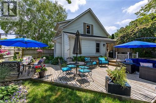 Expansive multi-level wood deck featuring a private fenced yard, mature perimeter trees, and direct access to the home - 5 Hawthorne Avenue, Simcoe, ON - Outdoor With Deck Patio Veranda