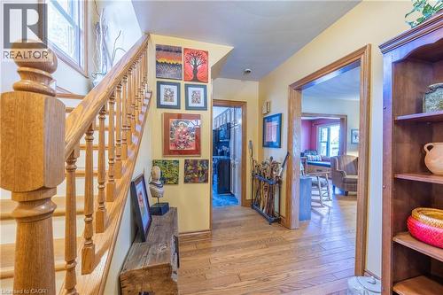 Hardwood flooring extends throughout the entryway, featuring a solid wood staircase with turned balusters and a substantial newel post - 5 Hawthorne Avenue, Simcoe, ON - Indoor Photo Showing Other Room