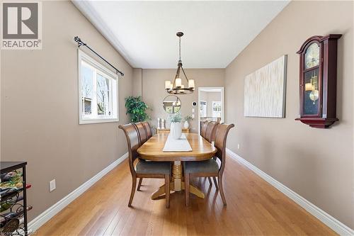 Dining area featuring wood-finish flooring, a window with white trim, and a chandelier light fixture - 29 Watson Crescent, Ayr, ON - Indoor Photo Showing Dining Room