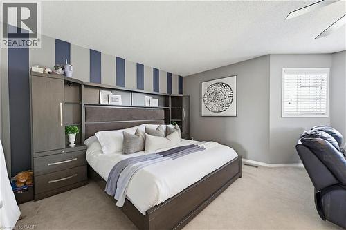 Bedroom featuring a built-in storage headboard, neutral carpeting, a window with blinds, and ceiling fan - 29 Watson Crescent, Ayr, ON - Indoor Photo Showing Bedroom