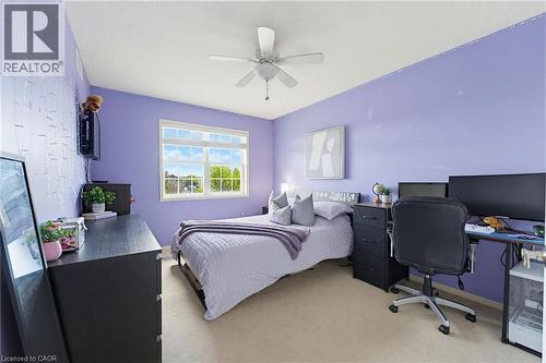 Bedroom featuring a multi-pane window, ceiling fan, and light-colored carpeting - 29 Watson Crescent, Ayr, ON - Indoor Photo Showing Bedroom