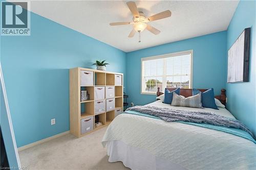 Carpeted room featuring a ceiling fan with integrated lighting, a window with horizontal blinds, and a built-in multi-cubby storage unit - 29 Watson Crescent, Ayr, ON - Indoor Photo Showing Bedroom