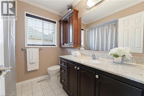 Bathroom featuring a dark wood-finish vanity with a light countertop, a single basin sink, and a large wall-mounted mirror - 29 Watson Crescent, Ayr, ON - Indoor Photo Showing Bathroom