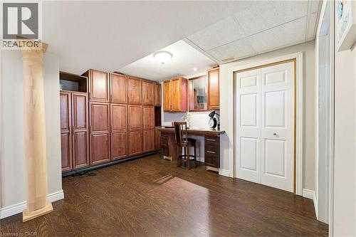 Dedicated workspace featuring extensive built-in cabinetry, wood-finish flooring, a bi-fold closet, and recessed lighting - 29 Watson Crescent, Ayr, ON - Indoor Photo Showing Other Room