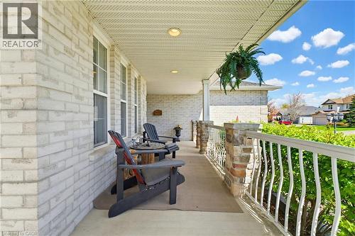 Covered front porch featuring white brick exterior, stone-clad pillars, white railing, and recessed lighting - 29 Watson Crescent, Ayr, ON - Outdoor With Deck Patio Veranda With Exterior