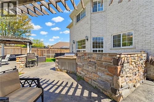 Spacious outdoor patio featuring a built-in stone outdoor kitchen with grill, a pergola, and a separate covered gazebo structure - 29 Watson Crescent, Ayr, ON - Outdoor