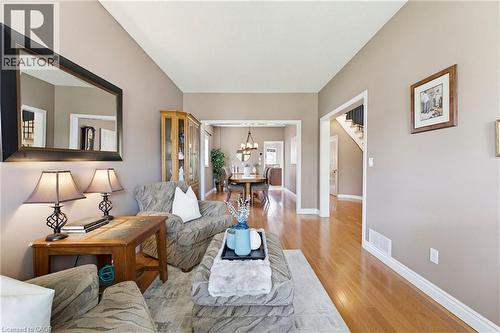 Hardwood flooring spans this room and extends through a wide archway to a dining area - 29 Watson Crescent, Ayr, ON - Indoor Photo Showing Living Room