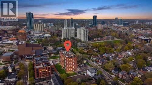 Cityscape featuring a multi-story brick building with multiple windows, surrounded by urban infrastructure and green spaces - 10 Ellen Street E Unit# 808, Kitchener, ON - Outdoor With View