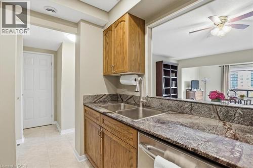 Kitchen sink area featuring a dual stainless steel sink, a pull-down faucet, and rich, veined stone countertops - 10 Ellen Street E Unit# 808, Kitchener, ON - Indoor Photo Showing Kitchen With Double Sink