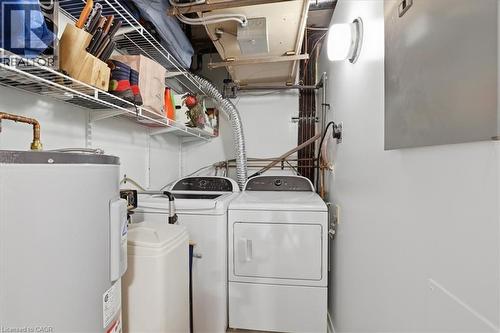 Dedicated laundry area featuring a top-load washing machine, front-load dryer, water heater, water softener, and wire shelving - 10 Ellen Street E Unit# 808, Kitchener, ON - Indoor Photo Showing Laundry Room