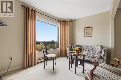Room featuring wall-to-wall carpeting, neutral wall finishes, and a large window with a broad outdoor expanse - 10 Ellen Street E Unit# 808, Kitchener, ON - Indoor Photo Showing Living Room