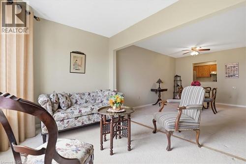 Carpeted living space featuring an open archway, ceiling fan, and window with drapes - 10 Ellen Street E Unit# 808, Kitchener, ON - Indoor Photo Showing Living Room