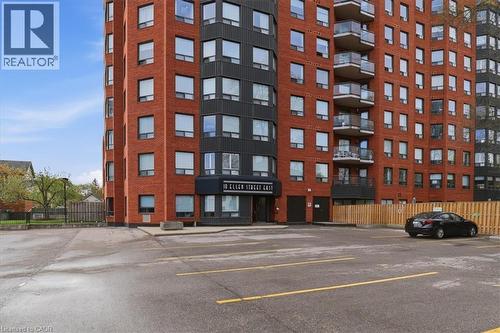 Brick and dark facade high-rise building with multiple windows and balconies featuring glass railings - 10 Ellen Street E Unit# 808, Kitchener, ON - Outdoor With Facade