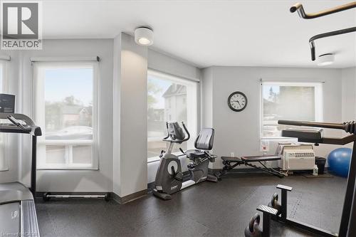 Dedicated fitness space featuring multiple windows with roller shades, recessed lighting, and durable dark-tone flooring - 10 Ellen Street E Unit# 808, Kitchener, ON - Indoor Photo Showing Gym Room