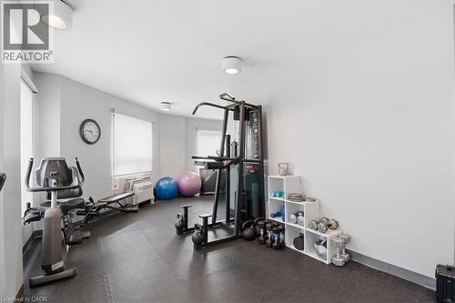 Dedicated fitness room featuring resilient rubber flooring, multiple windows with roller shades, and recessed lighting - 10 Ellen Street E Unit# 808, Kitchener, ON - Indoor Photo Showing Gym Room