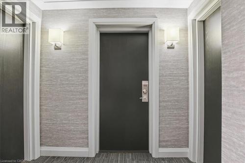 Hallway featuring textured wall covering, sconce lighting, and carpet flooring - 10 Ellen Street E Unit# 808, Kitchener, ON -  With Exterior