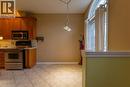Kitchen area featuring wood cabinetry, stainless steel appliances, and tiled flooring - 4066 Medland Drive, Burlington, ON  - Indoor Photo Showing Kitchen 