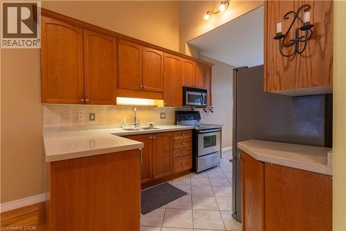 Kitchen featuring wood cabinetry, light-toned countertops, and a tiled backsplash - 4066 Medland Drive, Burlington, ON - Indoor Photo Showing Kitchen