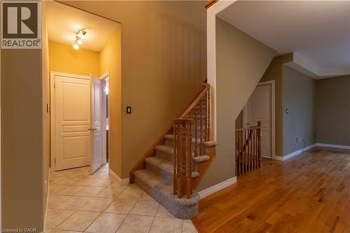 Split-level entryway featuring wood-finish flooring, a carpeted staircase with wood banister, and ceramic tile flooring in the hallway - 4066 Medland Drive, Burlington, ON - Indoor Photo Showing Other Room