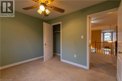 Carpeted room with sage green walls, white trim, and a ceiling fan with an amber-toned light fixture - 4066 Medland Drive, Burlington, ON - Indoor Photo Showing Other Room