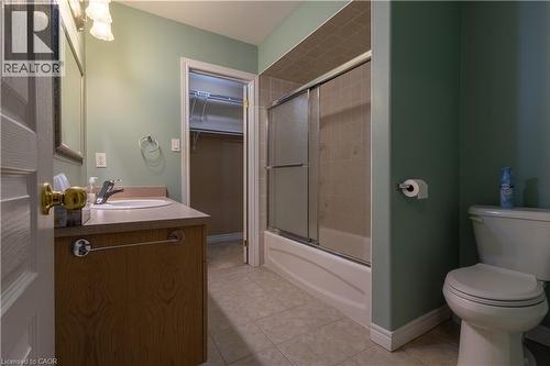 Bathroom featuring a wood-finish vanity with a light-toned countertop, a white drop-in sink, and a chrome faucet - 4066 Medland Drive, Burlington, ON - Indoor Photo Showing Bathroom