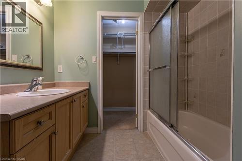 Bathroom featuring a single vanity with wood-finish cabinetry, a white oval sink, and a framed mirror - 4066 Medland Drive, Burlington, ON - Indoor Photo Showing Bathroom