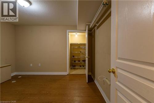 Interior room featuring wood-finish flooring, light beige walls, and white baseboards - 4066 Medland Drive, Burlington, ON - Indoor Photo Showing Other Room
