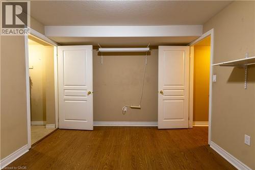 Warm wood-finish flooring complements the neutral wall tones - 4066 Medland Drive, Burlington, ON - Indoor Photo Showing Other Room