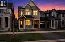 Traditional-style home featuring a brick and stone facade, covered front porch with white railings, and a prominent gable roofline - 3948 Thomas Alton Boulevard, Burlington, ON  - Outdoor With Facade 