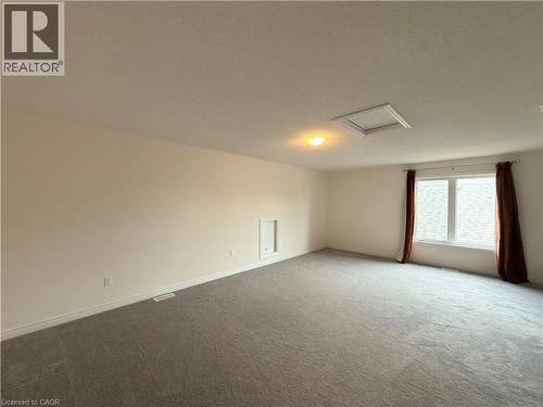Carpeted room featuring a large window, ceiling-mounted light fixture, and an access panel - 3948 Thomas Alton Boulevard, Burlington, ON - Indoor Photo Showing Other Room