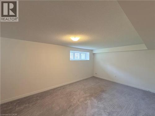 Light-colored carpeting, white walls, and a drop ceiling with recessed lighting - 3948 Thomas Alton Boulevard, Burlington, ON - Indoor Photo Showing Other Room