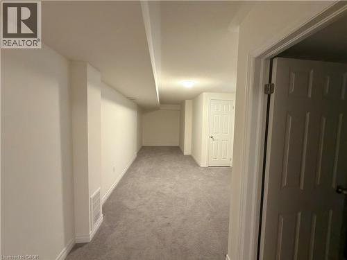 Spacious finished room featuring light gray carpeting, white painted walls, and overhead lighting - 3948 Thomas Alton Boulevard, Burlington, ON - Indoor Photo Showing Other Room