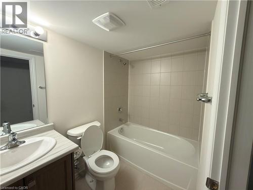 Bathroom featuring a white bathtub, ceramic tile surround, and a vanity with a white basin - 3948 Thomas Alton Boulevard, Burlington, ON - Indoor Photo Showing Bathroom