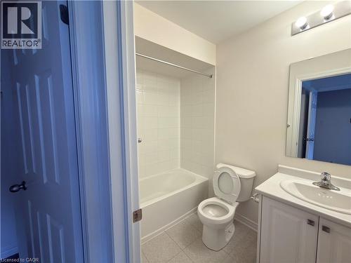 Bathroom featuring a white vanity with integrated sink, chrome faucet, and a rectangular mirror - 3948 Thomas Alton Boulevard, Burlington, ON - Indoor Photo Showing Bathroom