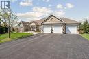 Stone facade residence featuring a three-car garage, asphalt driveway, and a covered portico entrance - 10 Brolley Crescent, Thornton, ON  - Outdoor With Facade 