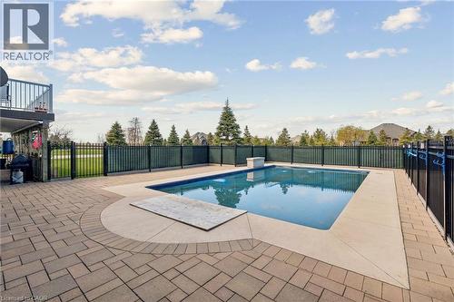 Rectangular swimming pool with a stone coping and surrounding paver patio - 10 Brolley Crescent, Thornton, ON - Outdoor With In Ground Pool