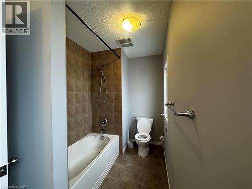 Bathroom featuring a shower/tub combination with subway tile surround, chrome fixtures, and a ceiling-mounted light fixture - 13 Sorrento Street, Kitchener, ON - Indoor Photo Showing Bathroom