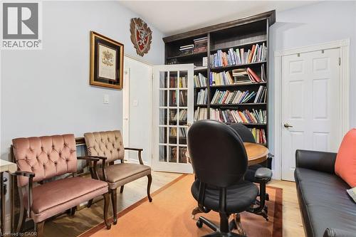 Integrated dark wood-finish bookshelves flank French doors with multiple glass panes - 189 Hughson Street, Hamilton, ON 