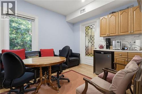 Compact kitchen area featuring wood cabinetry, light-toned countertops, and a tiled backsplash - 189 Hughson Street, Hamilton, ON 