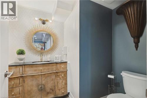 Powder room featuring a unique wood-finish vanity with a dark countertop and an undermount sink - 189 Hughson Street, Hamilton, ON 