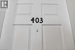 Panel-style entry door with a white finish, featuring black numerical designation and a peephole fixture - 