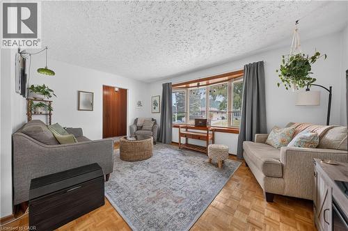 Bright living area featuring wood-finish parquet flooring and a large bay window - 111 Kimberly Crescent, Kitchener, ON 