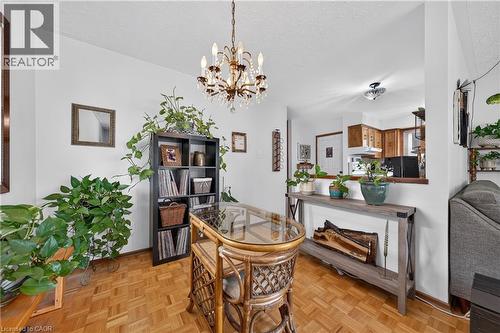 Dining area with parquet wood-finish flooring and a crystal chandelier - 111 Kimberly Crescent, Kitchener, ON 