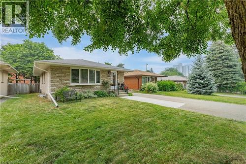Stone facade residence featuring a front yard with mature trees - 111 Kimberly Crescent, Kitchener, ON 