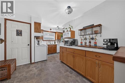 Kitchen with wood-finish cabinetry, solid surface countertops, and tile-look flooring - 111 Kimberly Crescent, Kitchener, ON 