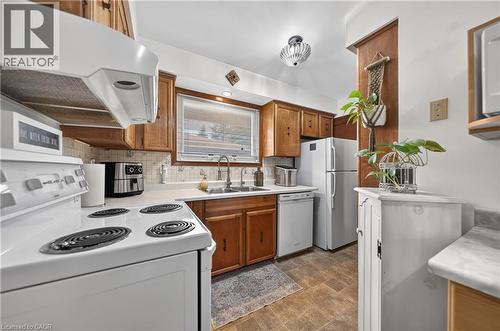 Kitchen featuring wood-finish cabinetry, light-toned countertops, and a tile backsplash - 111 Kimberly Crescent, Kitchener, ON 