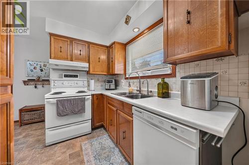 Kitchen featuring wood cabinetry, white countertops, a double basin stainless steel sink with dual faucets, an electric range, and a dishwasher - 111 Kimberly Crescent, Kitchener, ON 