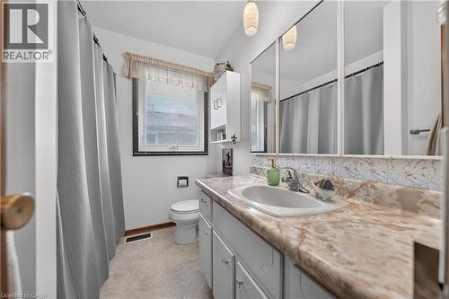 Bathroom featuring a vanity with an integrated sink, a laminate countertop, and ample storage cabinetry - 111 Kimberly Crescent, Kitchener, ON 